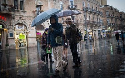 People walk in the rain on Jaffa street in downtown Jerusalem on February 14, 2017, as a rain storm hits the country. (Yonatan Sindel/Flash90)