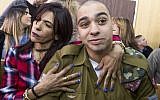 IDF Sgt. Elor Azaria, who shot dead a disarmed and injured Palestinian attacker in the West Bank city of Hebron in March 2016, is surrounded by family and friends as he awaits to hear his sentence in a courtroom at the Kirya military base in Tel Aviv, on February 21, 2017 (Jim Hollander/POOL)
