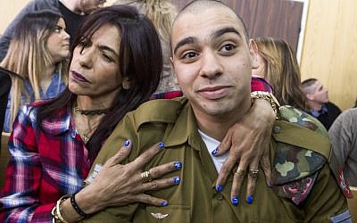 IDF Sgt. Elor Azaria, who shot dead a disarmed and injured Palestinian attacker in the West Bank city of Hebron in March 2016, is surrounded by family and friends as he awaits to hear his sentence in a courtroom at the Kirya military base in Tel Aviv, on February 21, 2017 (Jim Hollander/POOL)