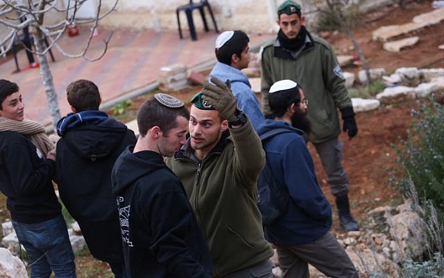 A Border Police officer argues with aight-wing activist during an operation to clear out nine houses in the Jewish settlement of Ofra, in the West Bank, on February 28, 2017. (Hadas Parush/Flash90)