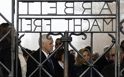 US Vice President Mike Pence, second from left, stands behind the gate with the infamous writing "Labor makes free" during a visit to the former Nazi concentration camp in Dachau near Munich, southern Germany, Sunday, Feb. 19, 2017. (AP Photo/Matthias Schrader)