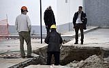 Experts check the location where an unexploded World War II bomb was found 5 meters (over 16 feet) deep, at a gas station in the northern Greek city of Thessaloniki, on Thursday, Feb. 9, 2016. Authorities in Greece's second-largest city on Sunday are planning to evacuate up to 60,000 residents from their homes so experts can safely dispose of the unexploded World War II bomb. (AP Photo/Giannis Papanikos)