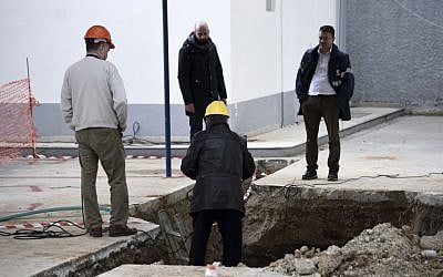 Experts check the location where an unexploded World War II bomb was found 5 meters (over 16 feet) deep, at a gas station in the northern Greek city of Thessaloniki, on Thursday, Feb. 9, 2016. Authorities in Greece's second-largest city on Sunday are planning to evacuate up to 60,000 residents from their homes so experts can safely dispose of the unexploded World War II bomb. (AP Photo/Giannis Papanikos)