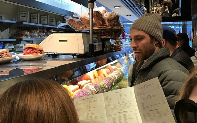 Shimmie Pesis gazes longingly into the deli case as he waits for a table at 2nd Avenue Deli in Midtown, New York. (Yaakov Schwartz/Times of Israel)