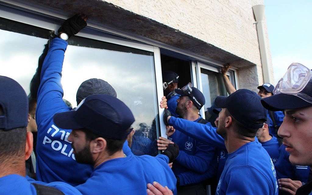 Police remove the windows of a house in Ofra as they prepare to clear the home of protesters on February 28, 2017 (Raoul Wootliff/ The Times of Israel)