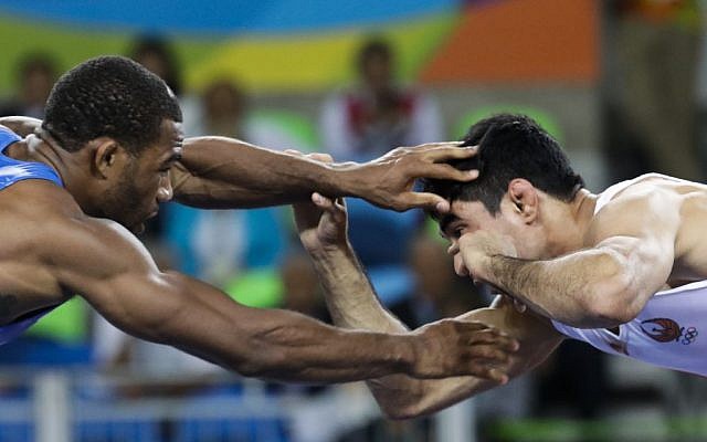 In this Aug. 19, 2016 file photo, United States' Jordan Ernest Burroughs, left, competes against Uzbekistan's Bekzod Abdurakhmonov during the men's 74-kg freestyle wrestling competition at the 2016 Summer Olympics in Rio de Janeiro, Brazil. Iran on Friday, Feb. 3, 2017, banned U.S. wrestlers from this month’s Freestyle World Cup in response to President Donald Trump's executive order forbidding visas for Iranians, the official IRNA news agency reported. (AP Photo/Markus Schreiber) In this Aug. 19, 2016 file photo, United States' Jordan Ernest Burroughs, left, competes against Uzbekistan's Bekzod Abdurakhmonov during the men's 74-kg freestyle wrestling competition at the 2016 Summer Olympics in Rio de Janeiro, Brazil. Iran on Friday, Feb. 3, 2017, banned U.S. wrestlers from this month’s Freestyle World Cup in response to President Donald Trump's executive order forbidding visas for Iranians, the official IRNA news agency reported. (AP Photo/Markus Schreiber)