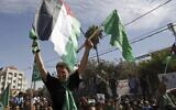 Hamas terrorist Nael Barghouti waves a green Islamic flag and a Palestinian flag to the crowd after arriving in the West Bank city of Ramallah after he was released as part of an exchange for Gilad Shalit, an Israeli soldier held by Hamas, October 18, 2011. (AP/Majdi Mohammed)
