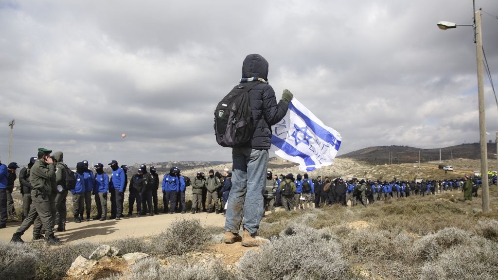 A settler holds an Israeli flag outside the West Bank outpost of Amona, Wednesday, February 1, 2017. (AP Photo/Oded Balilty) A settler holds an Israeli flag outside the West Bank outpost of Amona, Wednesday, February 1, 2017. (AP Photo/Oded Balilty)