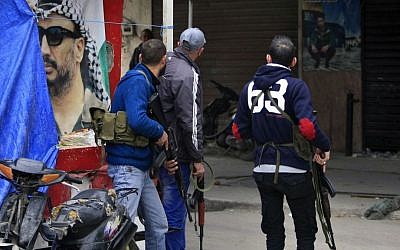 Palestinian gunmen from the Fatah movement hold their weapons as they stand in front of a poster of late Palestinian leader Yasser Arafat, during clashes between Fatah and Islamic groups in the Ein el-Hilweh refugee camp, in the southern port city of Sidon, Lebanon, Tuesday, Feb 28, 2017. (AP Photo/Mohammed ZaataPalestinian leader Yasser Arafat, during clashes between Fatah and Islamic groups in the Ein el-Hilweh refugee camp, in the southern port city of Sidon, Lebanon, Tuesday, Feb 28, 2017. (AP Photo/Mohammed Zaatari)