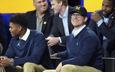 Michigan head football coach Jim Harbaugh smiles as he sits on stage during the "Signing of the Stars" event on national signing day at Crisler Center in Ann Arbor, Michigan, Wednesday, Feb. 1, 2017. (Melanie Maxwell/The Ann Arbor News via AP)