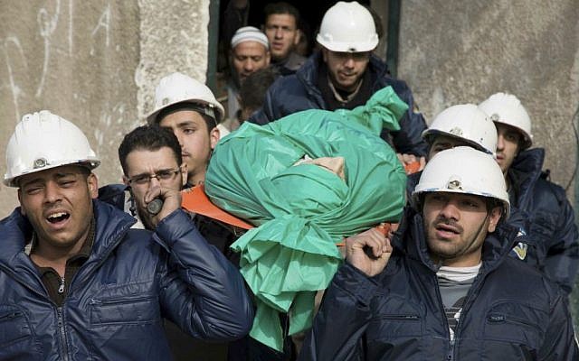 In this Sept. 16, 2015 file photo, comrades carry Ilias Mahmoud al-Taweel, a member of Syrian Civil Defense, popularly known as the White Helmets, during his funeral in Douma, Syria. (Feras Domy via AP, File)