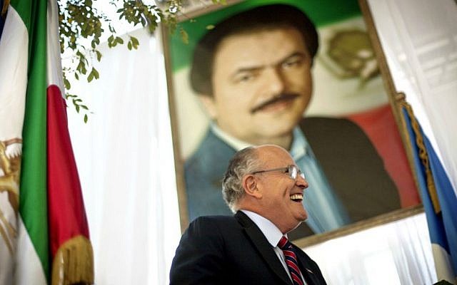 In this Thursday, Sept. 23, 2010 file photo, former New York City mayor Rudy Giuliani walks under a photo of Iranian opposition leader Massoud Rajavi as he takes the podium to speak at a protest of Iranian then-president Mahmoud Ahmadinejad's visit to the United Nations, in New York. (AP Photo/David Goldman, File)