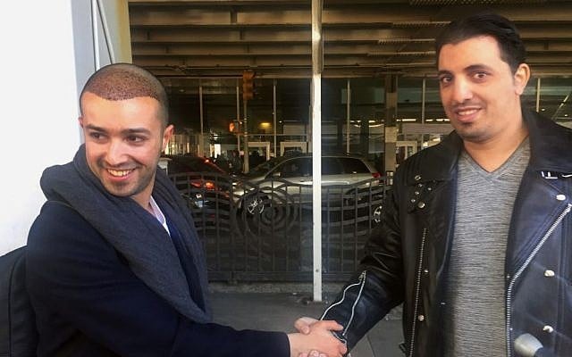 Ammar Alnajjar, left, shakes hands with his cousin, Fahd Alfakih, after coming into New York's JFK International Airport on a flight from Istanbul, Turkey, Saturday, Feb. 4, 2017 (AP Photo/William Mathis)