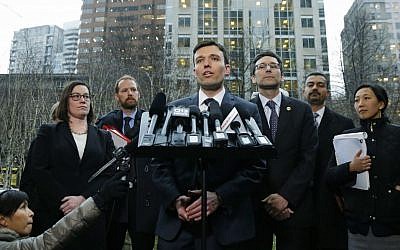 Washington state Solicitor General Noah Purcell, center, talks to reporters as Attorney General Bob Ferguson, third from right, looks on, Friday, Feb. 3, 2017, following a hearing in federal court in Seattle.(AP Photo/Ted S. Warren)