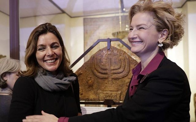 Director of the Vatican Museums, Barbara Jatta, left, and Director of Rome's Jewish Museum Alessandra Di Castro pose for a photo in front of a bas-relief showing a menorah at the end of a press conference in Rome, Monday, February 20, 2017. (AP/Alessandra Tarantino)