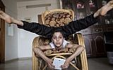 This file photo taken on April 28, 2016 shows then-twelve-year-old Palestinian teenager Mohammed al-Sheikh showing off his contortionist skills at his home in Gaza city. / AFP PHOTO / MAHMUD HAMS