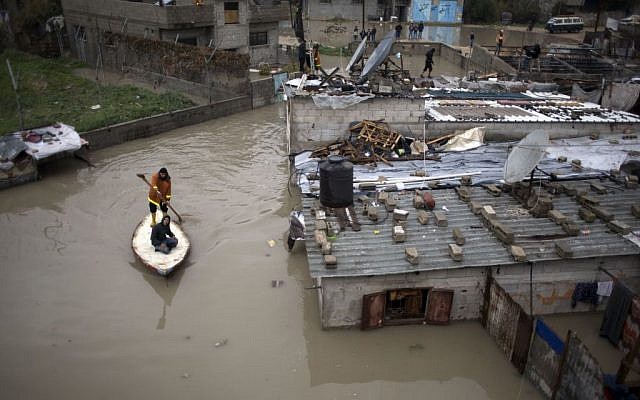 Palestinian rescuers members evacuate a man from a flooded home using a fishing boat during a heavy rain storm in Jabaliya refugee camp, northern Gaza Strip, Thursday, Feb. 16, 2017 (AP Photo/ Khalil Hamra)