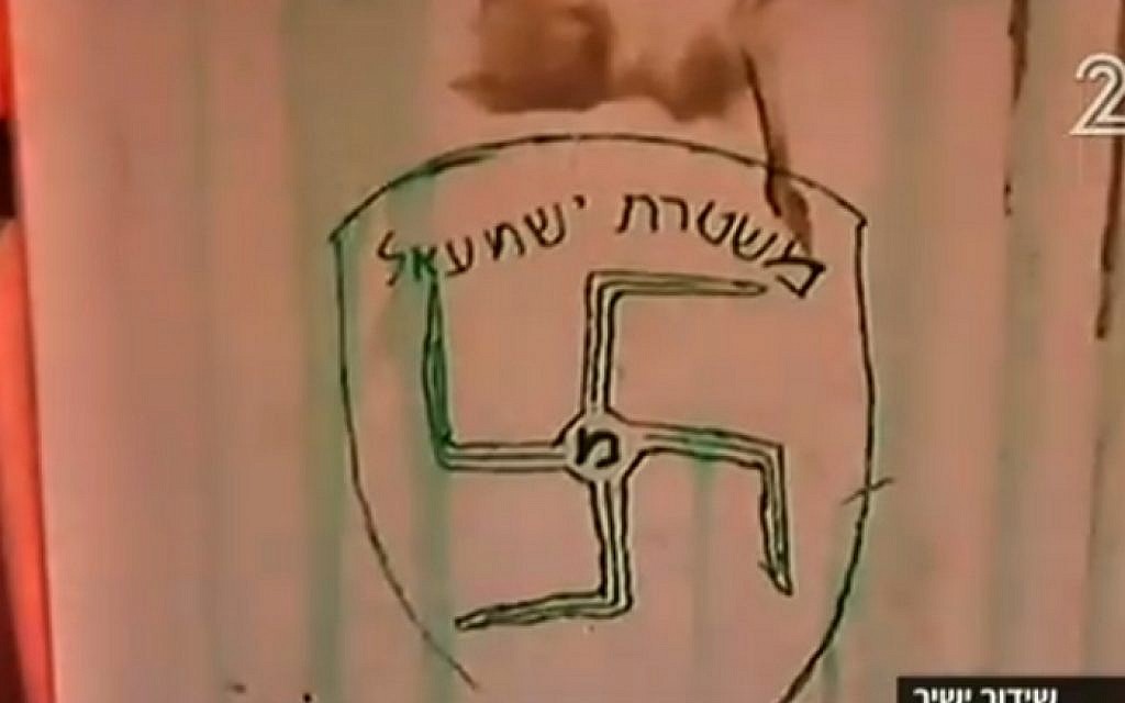 Graffiti daubed on the wall of Amona synagogue shows a swastika and the slogan 'Ishmael Police' -- a reference to the Israel Police force and to Ishmael, the son of the biblical patriarch Abraham believed by some to be the forebear of today's Arabs. (screen capture: Channel 2) Graffiti daubed on the wall of Amona synagogue shows a swastika and the slogan 'Ishmael Police' -- a reference to the Israel Police force and to Ishmael, the son of the biblical patriarch Abraham believed by some to be the forebear of today's Arabs. (screen capture: Channel 2)