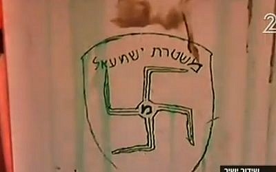 Graffiti daubed on the wall of Amona synagogue shows a swastika and the slogan 'Ishmael Police' -- a reference to the Israel Police force and to Ishmael, the son of the biblical patriarch Abraham believed by some to be the forebear of today's Arabs. (screen capture: Channel 2) Graffiti daubed on the wall of Amona synagogue shows a swastika and the slogan 'Ishmael Police' -- a reference to the Israel Police force and to Ishmael, the son of the biblical patriarch Abraham believed by some to be the forebear of today's Arabs. (screen capture: Channel 2)