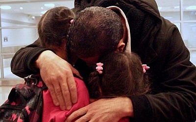Fadi Kassar hugs his young daughters for the first time in over 2 years after his family was reunited at John F. Kennedy Airport in New York City on February 2, 2017. (Bill Swersey/HIAS) 