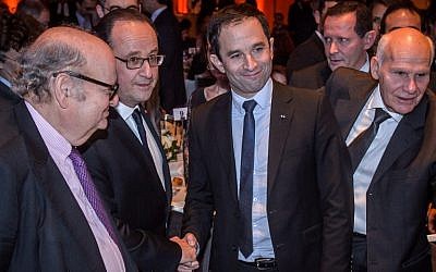 French President Francois Hollande (2nd-L) shakes hands with French presidential candidate for the left-wing French Socialist Party (PS) Benoit Hamon (2nd-R) during the 32nd annual dinner of the Jewish Institutions Representative Council (Conseil Representatif des Institutions Juives de France - CRIF) in Paris, on February 22, 2017. / AFP PHOTO / POOL / Christophe Petit Tesson