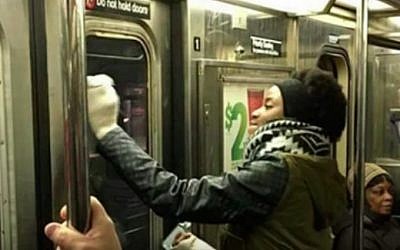 New York commuters scrub anti-Semitic graffiti from a subway car (YouTube screenshot)