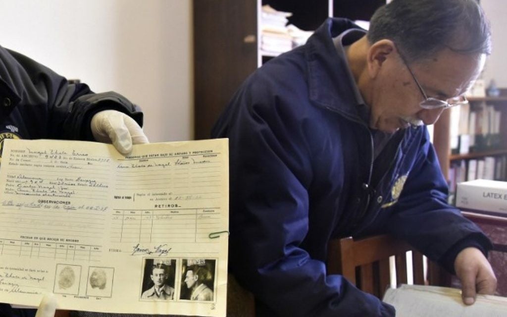 Edgar Ramirez right), the head of the archives in the Bolivian state mining company COMIBOL, with unearthed documents which reveal that Jewish-German tin baron Mauricio Hochschild helped thousands of Jews escape Nazism, in El Alto, Bolivia. (Aizar Raldes/AFP) Edgar Ramirez right), the head of the archives in the Bolivian state mining company COMIBOL, with unearthed documents which reveal that Jewish-German tin baron Mauricio Hochschild helped thousands of Jews escape Nazism, in El Alto, Bolivia. (Aizar Raldes/AFP)