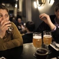 Jafar Farah (R) and his wife Asmahan Atwan Farah drink beer at the Libira Brewery pub in Haifa on February 23, 2017. (AFP Photo/Menahem Kahana)