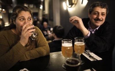 Jafar Farah (R) and his wife Asmahan Atwan Farah drink beer at the Libira Brewery pub in Haifa on February 23, 2017. (AFP Photo/Menahem Kahana)