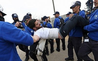 Israeli police forces evacuate protesters on February 28, 2017 in the West Bank settlement of Ofra, during an operation by Israeli forces to demolish nine buildings. (AFP Photo/Menahem Kahana)