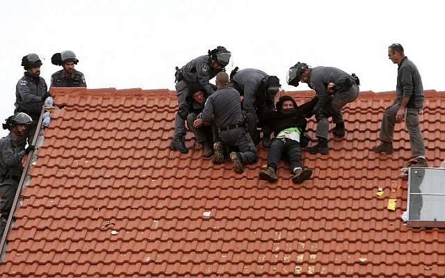 Israeli police remove protesters from the roof of a home slated to be destroyed in the West Bank settlement of Ofra on March 1, 2017. (AFP Photo/Menahem Kahana) Israeli police remove protesters from the roof of a home slated to be destroyed in the West Bank settlement of Ofra on March 1, 2017. (AFP Photo/Menahem Kahana)