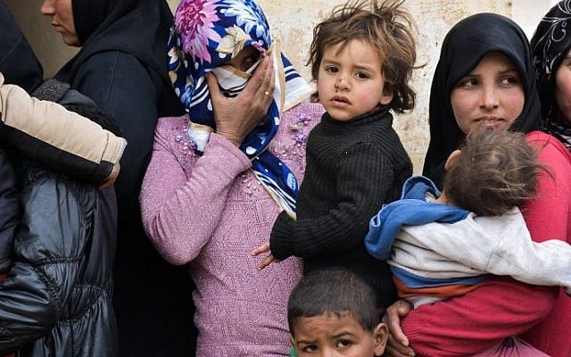 Displaced Syrian women queue up to receive medical aid and vaccines from Russian Army forces through pediatric field hospitals in the district of Jibreen, on the outskirts of the northern Syrian city of Aleppo on March 1, 2017. (AFP PHOTO / George OURFALIAN)