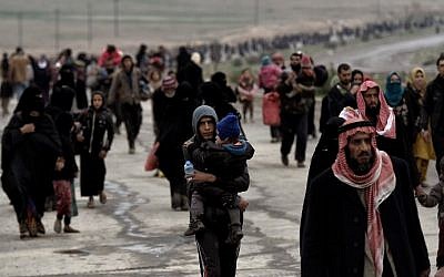 Iraqi families walk down a road as they flee Mosul on March 3, 2017, during an offensive by security forces to retake the western parts of the city from Islamic State (IS) group fighters. (AFP Photo/Aris Messinis)