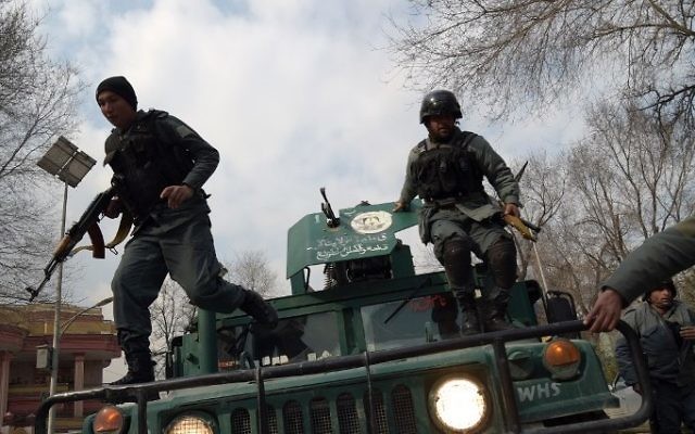 Afghan policemen leap from a vehicle as they arrive at the site of an explosion in Kabul on March 8, 2017. An explosion and gunfire rattled Kabul's diplomatic district, as insurgents attacked Afghanistan's largest military hospital, officials said. (AFP PHOTO / SHAH MARAI)
