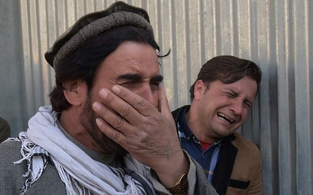 Two Afghan men weep for their relatives in front of the main gate of a military hospital in Kabul on March 8, 2017, after a deadly six-hour attack claimed by the Islamic State group. (AFP PHOTO / SHAH MARAI) Two Afghan men weep for their relatives in front of the main gate of a military hospital in Kabul on March 8, 2017, after a deadly six-hour attack claimed by the Islamic State group. (AFP PHOTO / SHAH MARAI)