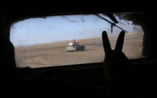 Iraqi government forces supported by fighters from the Abbas Brigade, which fight under the umbrella of the Shiite popular mobilization units, advance in village of Badush, some 15 kilometers northwest of Mosul, during the ongoing battle to retake the city's west from Islamic State (IS) jihadists on March 8, 2017. (AFP PHOTO / Mohammed SAWAF)