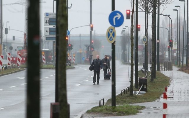 Evacuated hotel guests walk down a road near the site where a unexploded World War II bomb was found in Duesseldorf, western Germany, on March 9, 2017. (David Young/AFP)