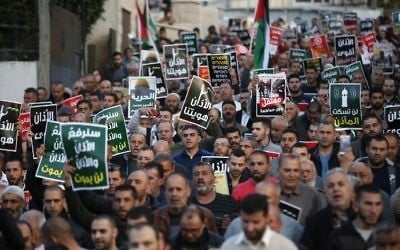 Arab Israelis march in the northern Arab town of Kabul, near Acre, during a demonstration against planned Israeli legislation to silence mosque loudspeakers, on March 11, 2017. The writing in Arabic reads: 'Our mosques won't be silenced.' (AFP/Ahmad Gharabli)