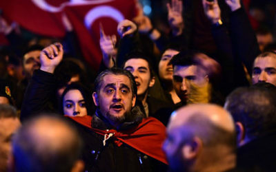 People gesture and wave flags as Turkish residents of the Netherlands gather for a protest outside Turkey's consulate in Rotterdam on March 11, 2017. (Emmanuel Dunand/AFP)
