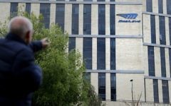 A man walks past the logo of Israeli car tech firm Mobileye on the company's offices in Jerusalem on March 13, 2017. (AFP PHOTO / THOMAS COEX)