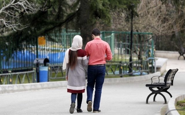 An Iranian couple walk in a park in the capital Tehran on March 14, 2017. (AFP/ATTA KENARE) An Iranian couple walk in a park in the capital Tehran on March 14, 2017. (AFP/ATTA KENARE)