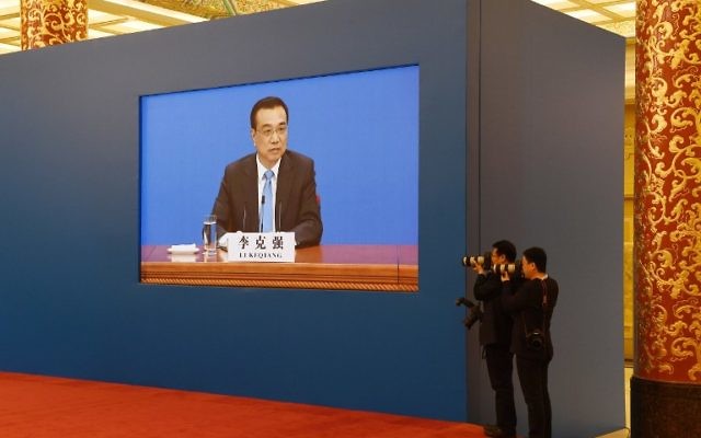 Two photographers take photos of Chinese Premier Li Keqiang as a live image of him is seen on a screen behind them during a press conference after the closing session of the National People's Congress in the Great Hall of the People in Beijing on March 15, 2017. (Greg Baker/AFP) Two photographers take photos of Chinese Premier Li Keqiang as a live image of him is seen on a screen behind them during a press conference after the closing session of the National People's Congress in the Great Hall of the People in Beijing on March 15, 2017. (Greg Baker/AFP)