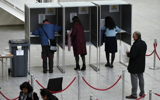 Dutch people stand in voting booths before as they vote for Dutch general elections at a polling station on March 15, 2017 in The Hague.(AFP PHOTO / JOHN THYS)