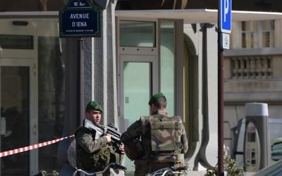 French Army soldiers stand guard near the main entrance of the Paris offices of the International Monetary Fund (IMF) on March 16, 2017 in Paris, after a letter bomb exploded in the premises. (Christophe Archambault/AFP) 
