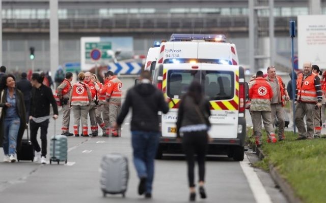 French Red Cross workers stand by as travelers are evacuated from Paris' Orly airport on March 18, 2017 following the shooting of a man by French security forces. (Benjamin CREMEL)