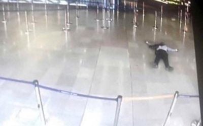 A picture taken from the screen of a monitor on March 18, 2017 shows a man lying on the ground  of a terminal building at Paris' Orly airport after he was shot by French security forces for taking a weapon from a soldier. (AFP)