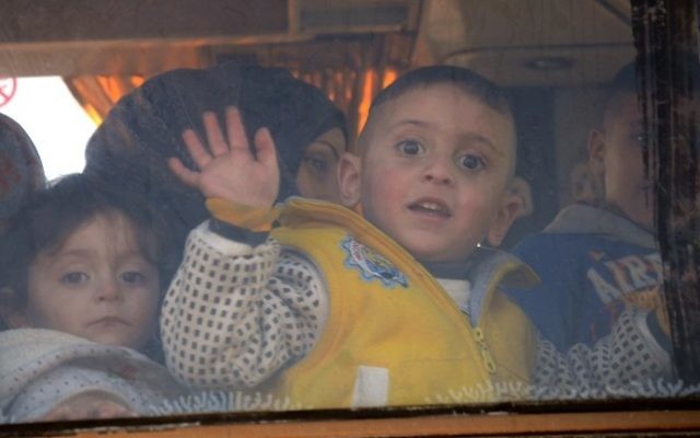 A child waves from the window of a bus as Syrians who were evacuated from Waer, the last opposition-held district of Homs, arrive in the northern Syrian town of al-Bab on March 19, 2017. (AFP PHOTO / Nazeer al-Khatib) A child waves from the window of a bus as Syrians who were evacuated from Waer, the last opposition-held district of Homs, arrive in the northern Syrian town of al-Bab on March 19, 2017. (AFP PHOTO / Nazeer al-Khatib)
