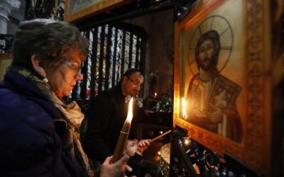 Christian worshippers light candles around the Edicule of the Tomb of Jesus (where his body is believed to have been laid) at the Church of the Holy Sepulchre in Jerusalem's Old City on March 21, 2017 (Gali Tibbon/AFP) Christian worshippers light candles around the Edicule of the Tomb of Jesus (where his body is believed to have been laid) at the Church of the Holy Sepulchre in Jerusalem's Old City on March 21, 2017 (Gali Tibbon/AFP)