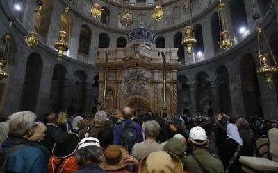 Tourists and worshippers wait to access the newly restored shrine surrounding what is believed to be Jesus's tomb which was unveiled at a ceremony in Jerusalem on March 22, 2017 following months of delicate work. (Menahem Kahana/AFP)