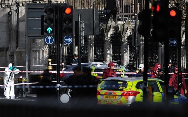 Armed police officers stand guard as forensics officers work around a grey vehicle that crashed into the railings of the Houses of Parliament in central London on March 22, 2017. (AFP Photo/Daniel Sorabji)